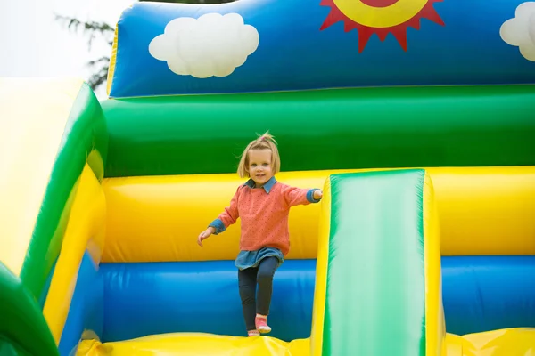 Liten flicka som leker på en studsmatta. — Stockfoto