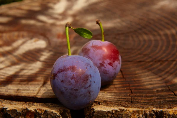 Fresh plums on wooden table — Stock Photo, Image