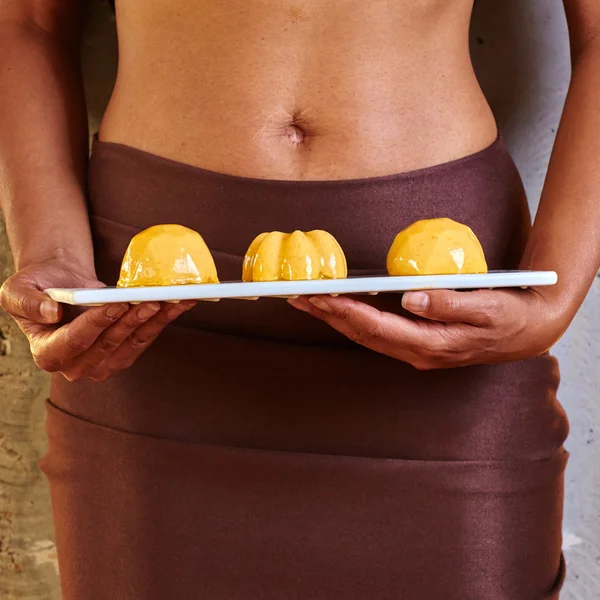 Dessert in der Hand auf Höhe des Bauches. — Stockfoto