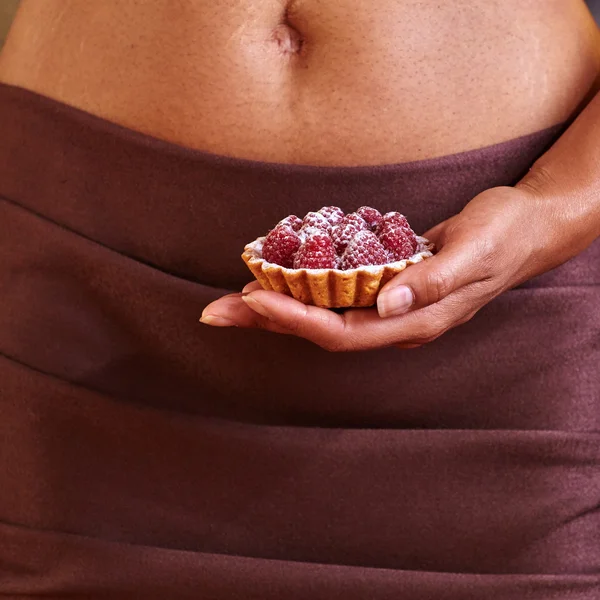 Dessert in hand at level of the abdomen. — Stock Photo, Image