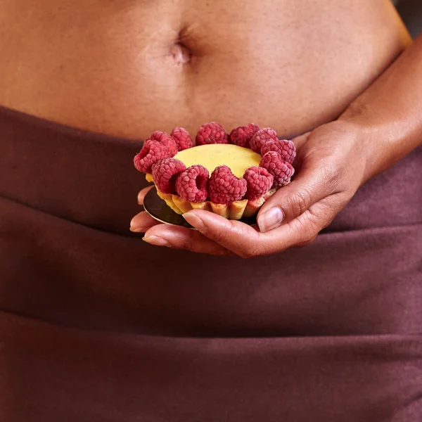 Dessert in hand at level of the abdomen. — Stock Photo, Image