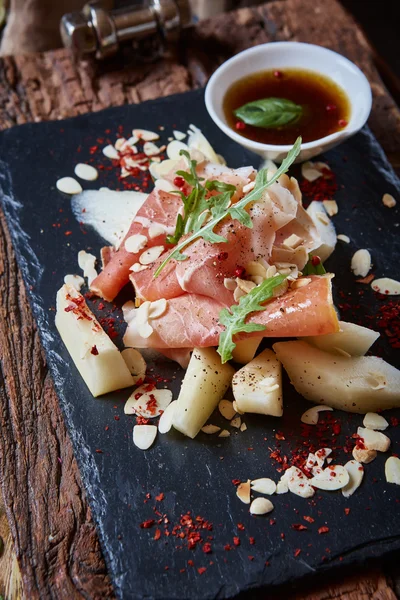 Salad of fresh melon with thin slices prosciutto — Stock Photo, Image