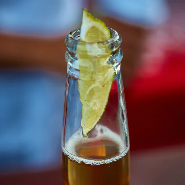 Cerveja gelada em uma garrafa com limão cunha — Fotografia de Stock