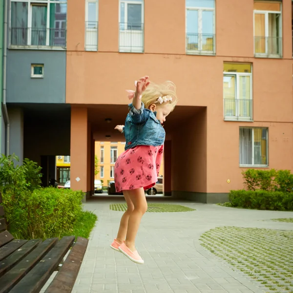 Boldog kis gyermek, kisgyermek szőke lány jumping — Stock Fotó