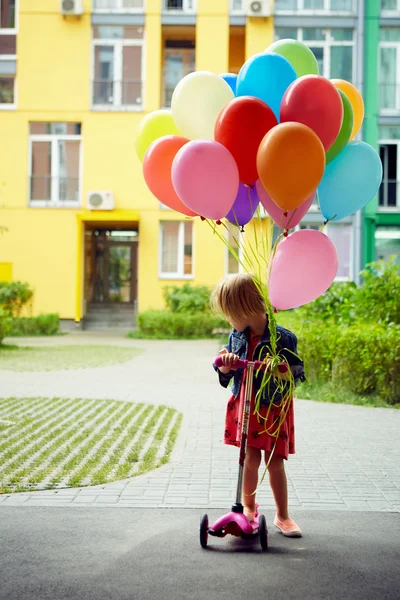 Gelukkig meisje buitenshuis met ballonnen — Stockfoto