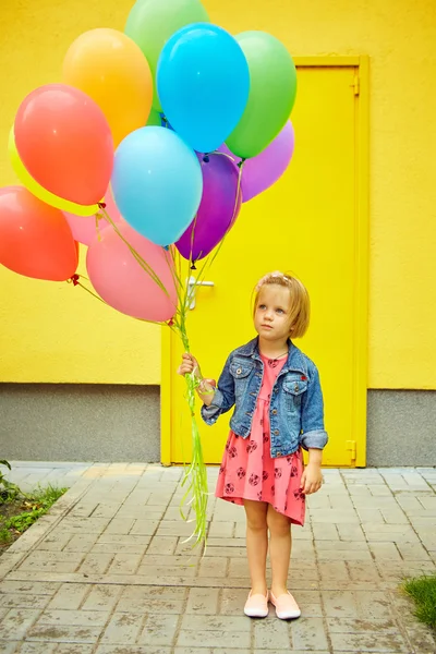 Glad liten flicka utomhus med ballonger — Stockfoto