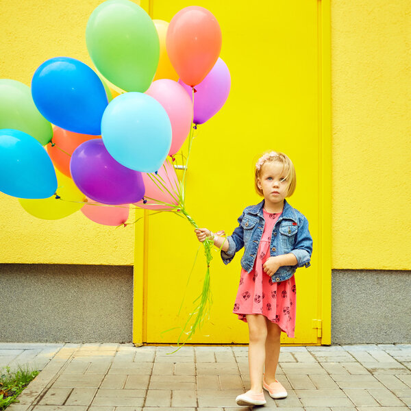 happy little girl outdoors with balloons