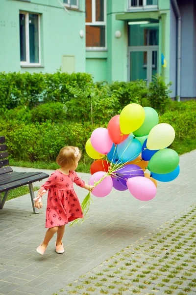 Gelukkig meisje buitenshuis met ballonnen — Stockfoto