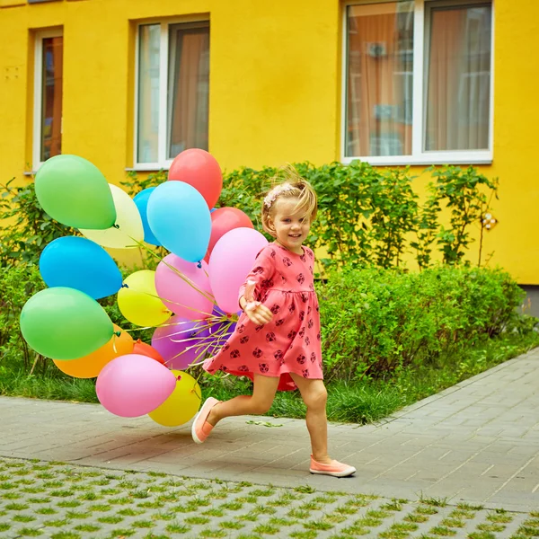 Gelukkig meisje buitenshuis met ballonnen — Stockfoto