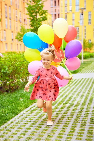 Šťastná holčička venku s balónky — Stock fotografie
