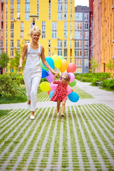 Mutter und Kind mit bunten Luftballons — Stockfoto