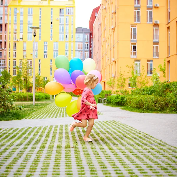 Happy little girl outdoors with balloons — Stock Photo, Image