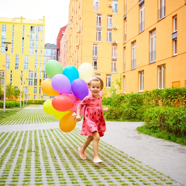 Šťastná holčička venku s balónky — Stock fotografie