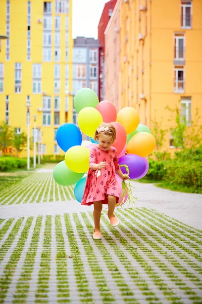 Šťastná holčička venku s balónky — Stock fotografie