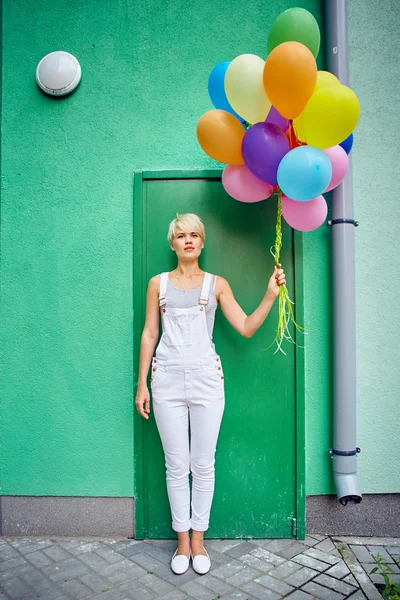 Happy young woman with colorful latex balloons — Stock Photo, Image