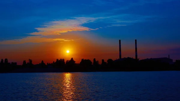 Fábrica en silueta y cielo del amanecer — Foto de Stock