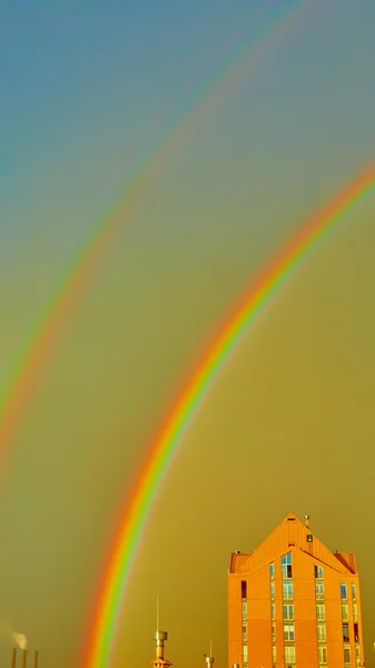 Dubbele regenboog over de stad — Stockfoto