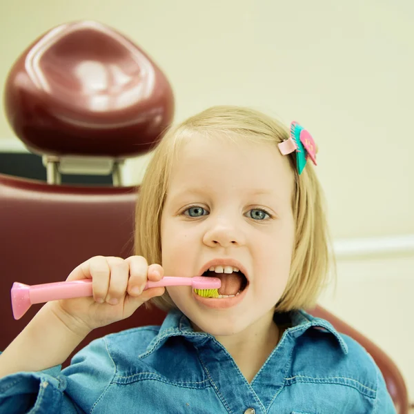 Niña sentada en el consultorio de dentistas —  Fotos de Stock