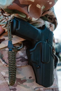 Taktik kılıfında bir askerin tabancası. Hazırlık, savunma ve modern güvenlik operasyonları kavramı.