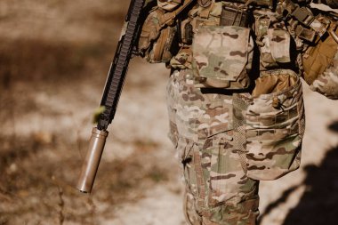 Kamuflaj ve taktik teçhizatlı bir asker. Modern savaş, savunma ve küresel güvenlik kavramı.