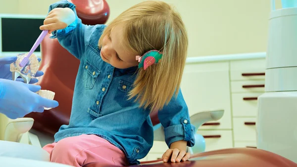 Niña sentada en el consultorio de dentistas — Foto de Stock