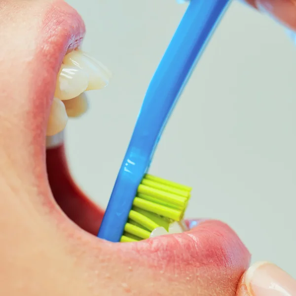 Dentista mostrando a una mujer cómo cepillarse los dientes — Foto de Stock
