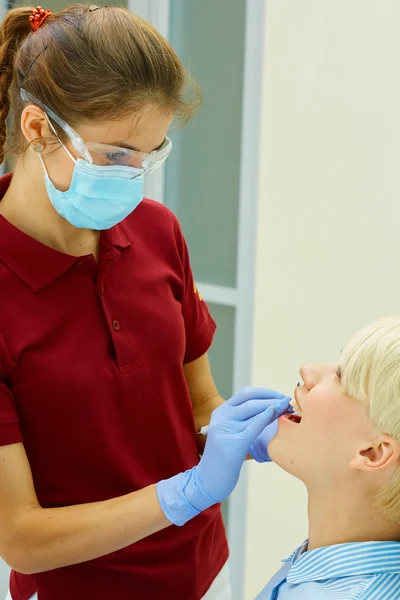 Dentista curando a una paciente femenina —  Fotos de Stock