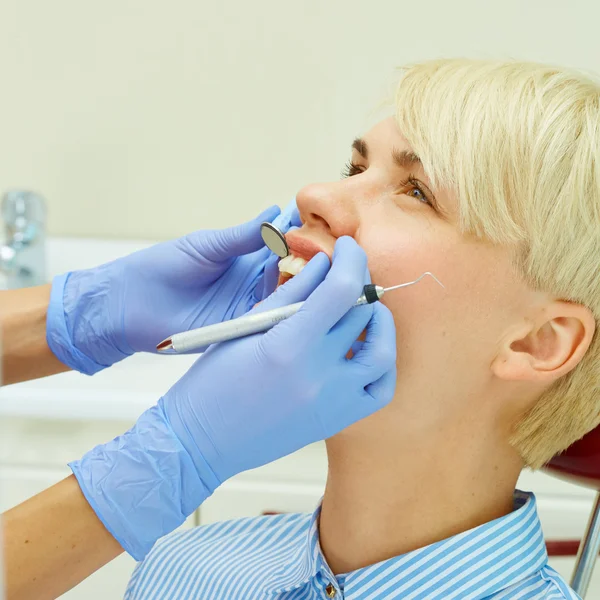 Dentista curando a una paciente femenina — Foto de Stock
