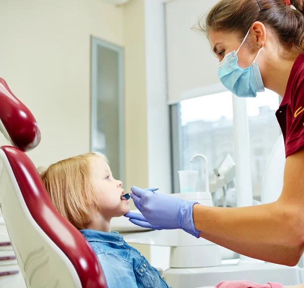 Dentista pediátrico examinando dentes meninas na cadeira dentistas — Fotografia de Stock