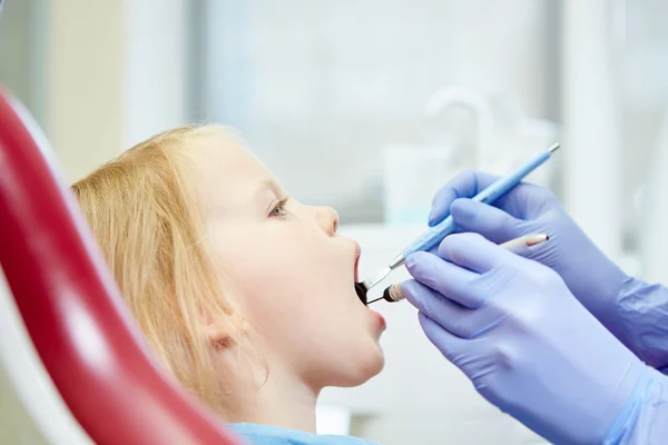 Dziecięca dentysta bada zęby mało dziewczyn w fotelu Dentyści — Zdjęcie stockowe