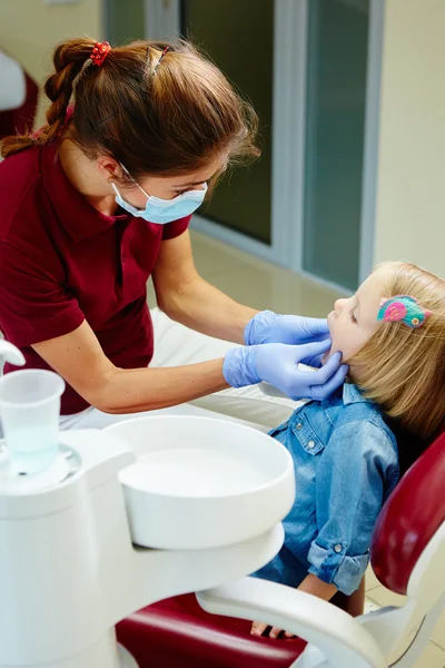 Dziecięca dentysta bada zęby mało dziewczyn w fotelu Dentyści — Zdjęcie stockowe