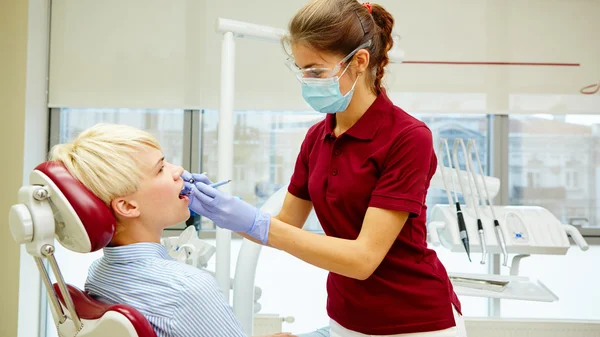 歯医者は女性患者を治療し — ストック写真