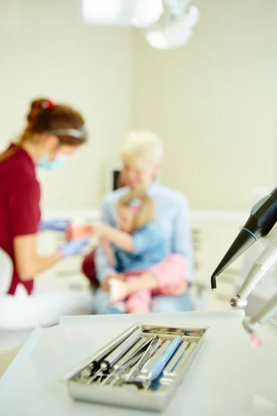 Pediatric tandläkare förklara för ung patient och hennes mor modellen — Stockfoto