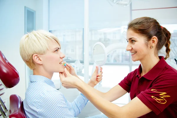 Dentista curando a una paciente femenina — Foto de Stock