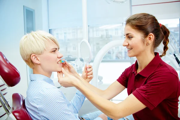 Dentista curando a una paciente femenina — Foto de Stock