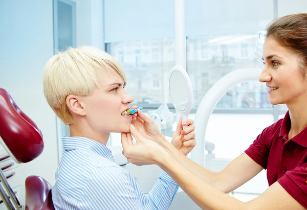 Dentista curando a una paciente femenina — Foto de Stock