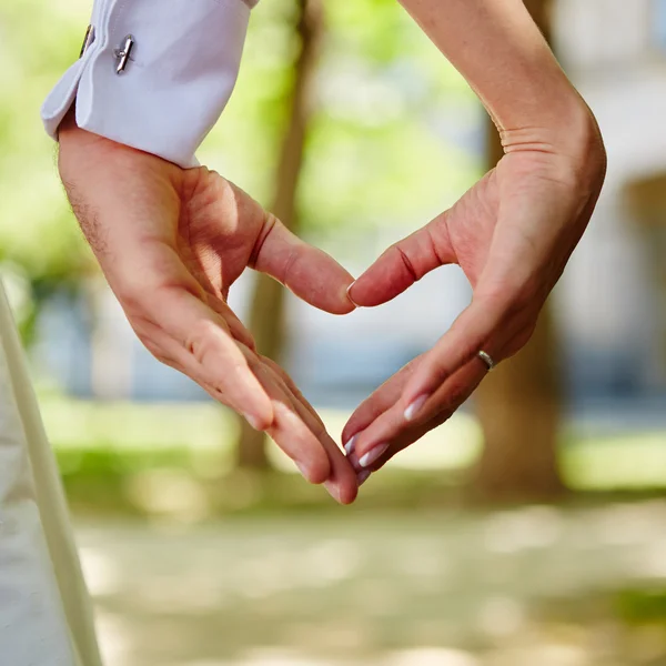 Handen bruid en bruidegom in de vorm van hart — Stockfoto