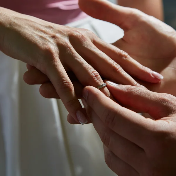 Bruidegom zet ring op de vinger van de bruid — Stockfoto