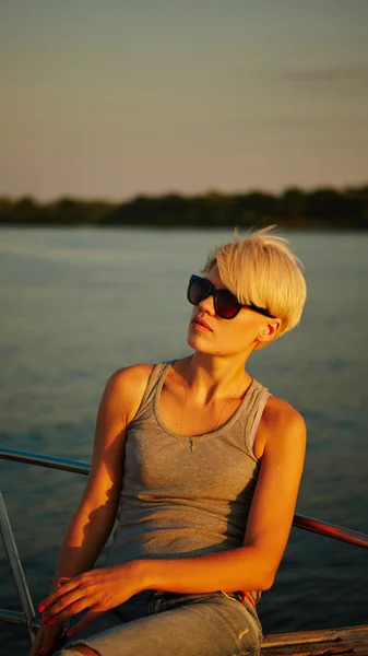 Woman traveling by boat at sunset — Stock Photo, Image