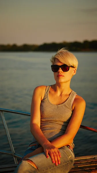 Woman traveling by boat at sunset — Stock Photo, Image