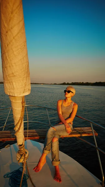 Woman traveling by boat at sunset — Stock Photo, Image