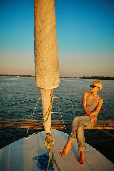 Mulher viajando de barco ao pôr do sol — Fotografia de Stock