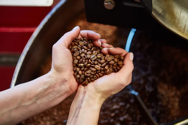 Detailní pohled na pražené kávové boby v ruce — Stock fotografie