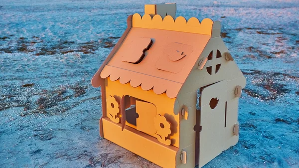Casa de juguete de cartón ondulado en la costa del mar al atardecer . —  Fotos de Stock