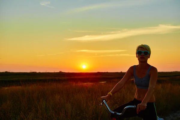 Biker-girl at the sunset — Stock Photo, Image