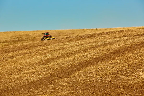 Agrarische landschap. Trekker werken op het veld. — Stockfoto
