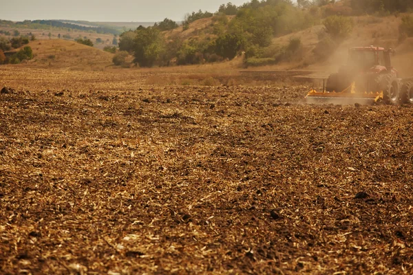 Agrarische landschap. Trekker werken op het veld. — Stockfoto