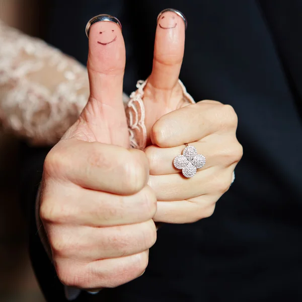 Wedding rings on her fingers painted with the bride and groom — Stock Photo, Image