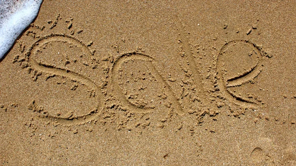 Wortverkauf handgeschrieben im Sand — Stockfoto