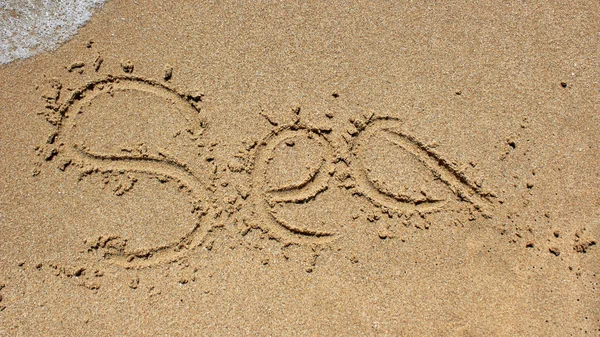 Palavra do mar escrita na areia da praia . — Fotografia de Stock